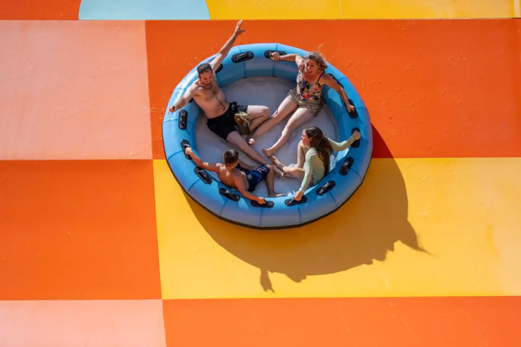 A family holds onto their raft as they ride up...