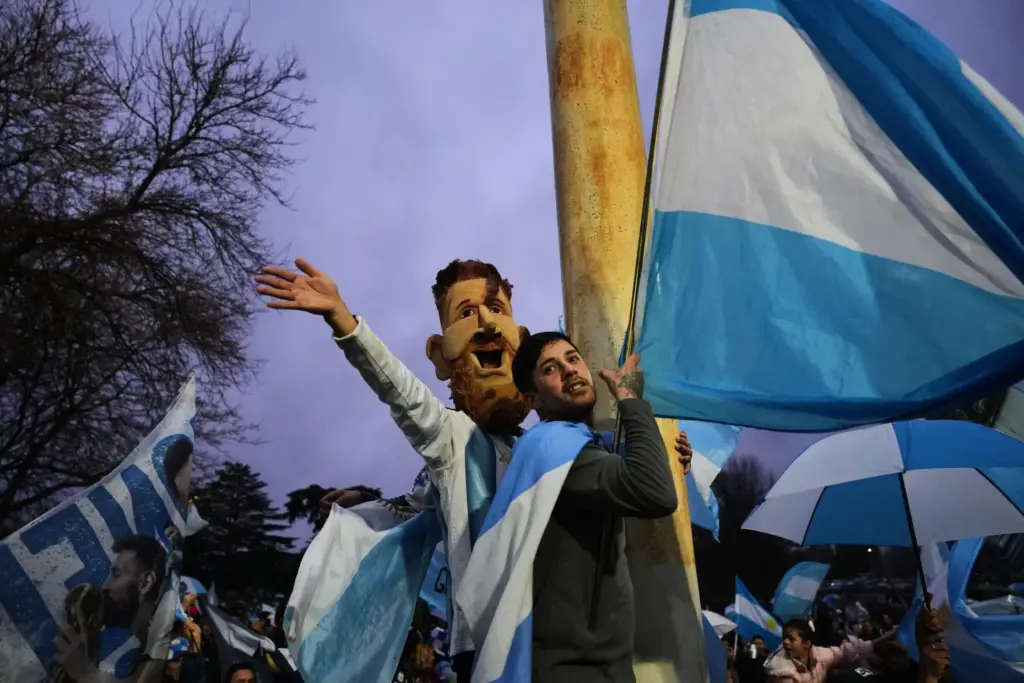 An Argentina fan wearing a mask depicting Lionel Messi gathers...