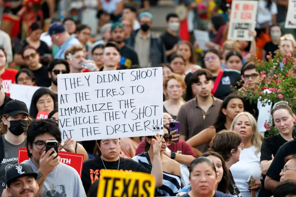 A woman holds up a sign during a vigil for...