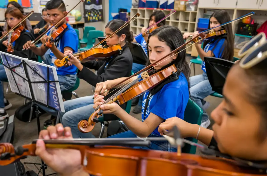 Students in the intermediate violin class practice during the 15th...