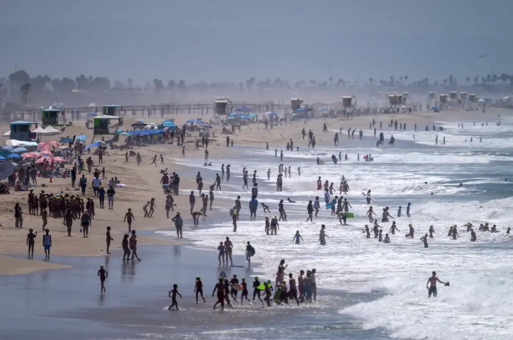 Beachgoers, including junior lifeguard groups, hang out south of the...