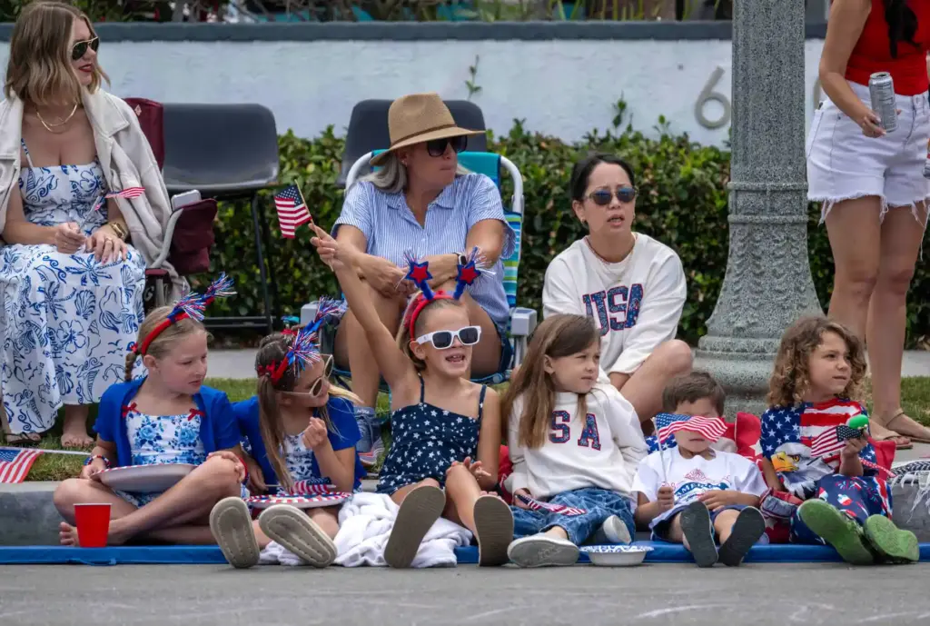Kids wave to parade participants during the annual Huntington Beach...