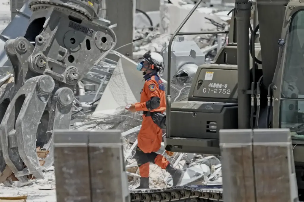 A firefighter searches the damaged AEON Mall following an explosion triggered by an earthquake.