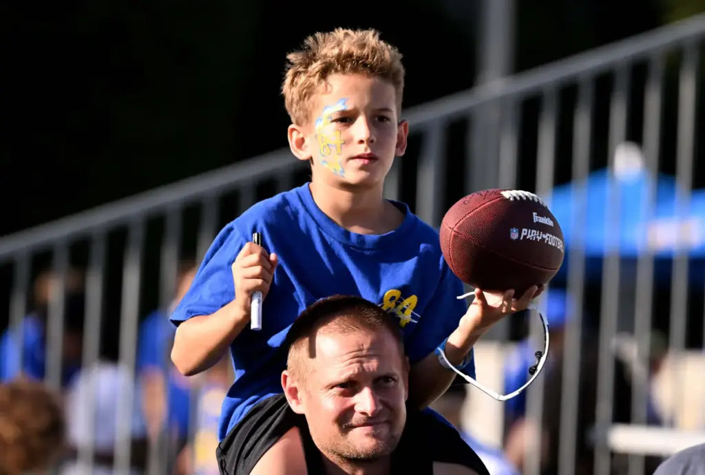 A young fan waits for an autogrph from Rams tight...