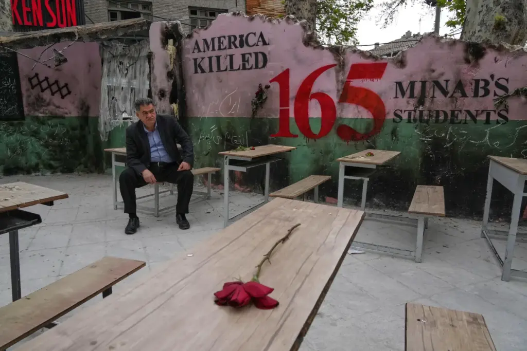 FILE – A man sits on a bench in a...