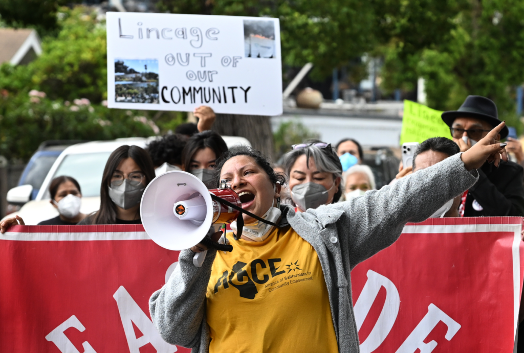 Elizabeth Hernandez uses a bullhorn. Residents and community organizations held...