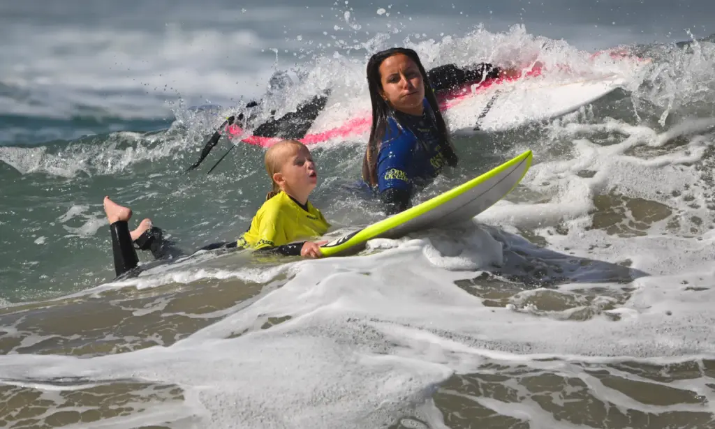 Pro surfer Ariane Ochoa works with Lindsey Martin, 6, during...