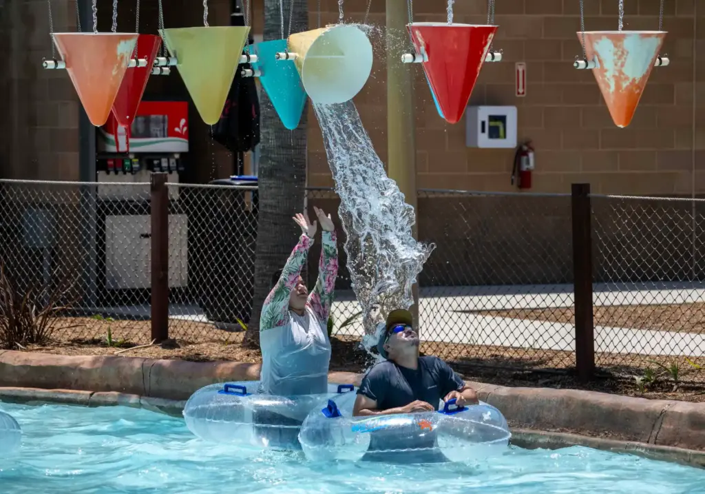 Buckets dump water on Wild Rivers guests as they float...