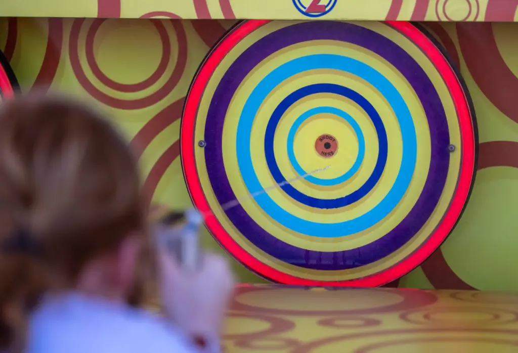 A fairgoer shoots water at a target as she plays...