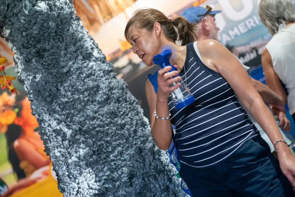 A Great American State Fair visitor uses a fan to cool down.