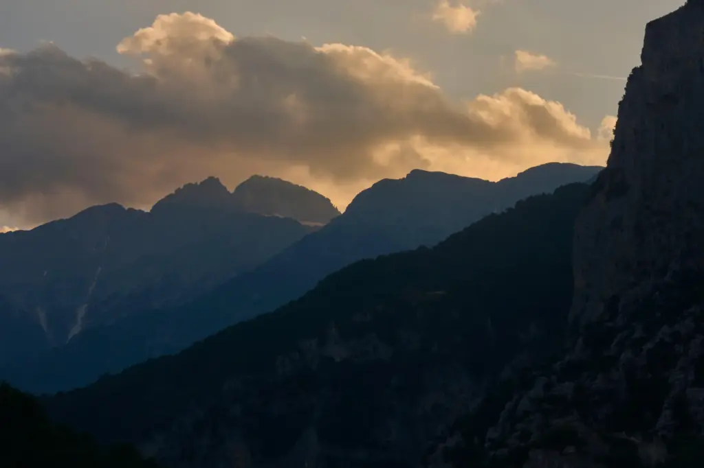 The setting sun illuminates the clouds above Mytikas and Stefani,...