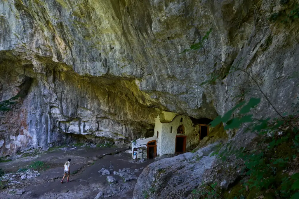 A visitor approaches a chapel at the Holy Cave of...