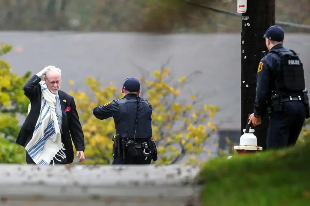 FILE – Rabbi Jeffrey Myers holds his head as he...