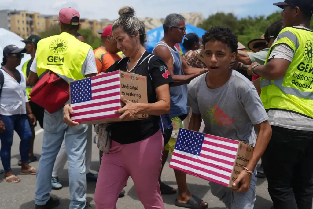 People affected by the earthquakes carry U.S. humanitarian aid.