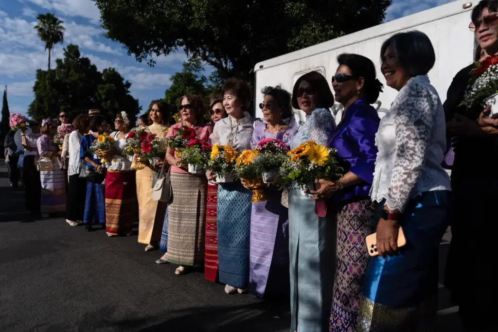 Attendees hold flowers while waiting to greet Bhikkhu Pannakara, a...