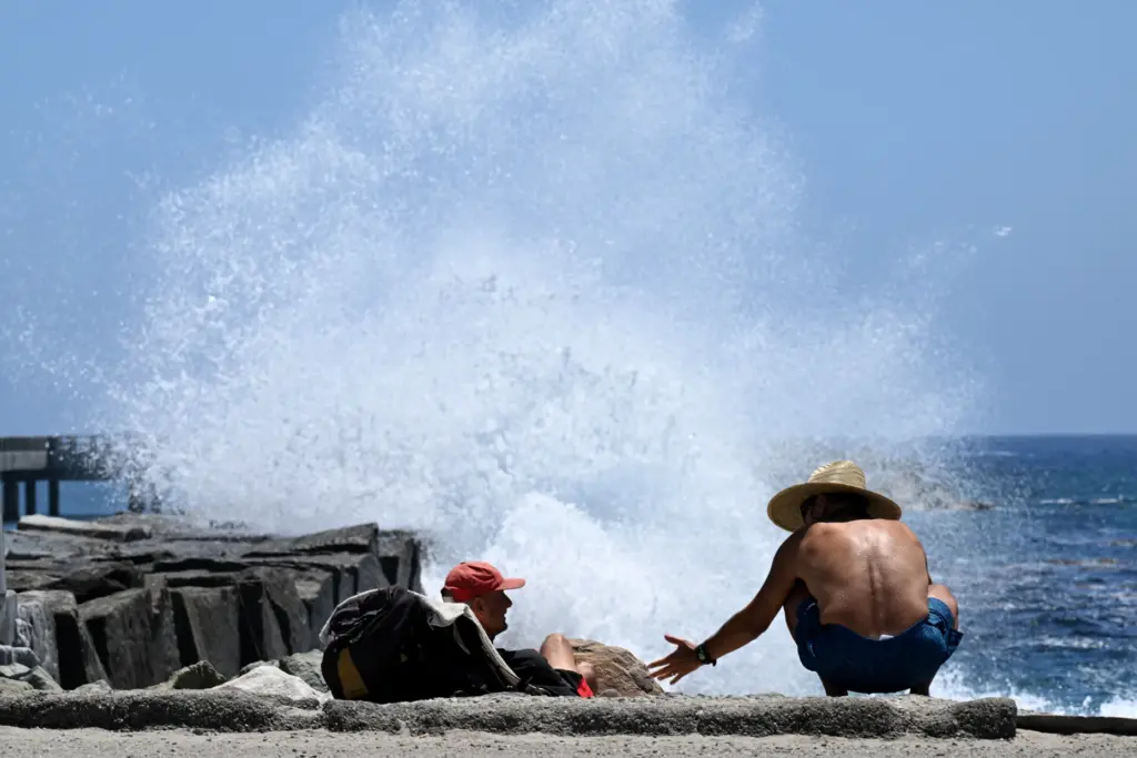 Two friends enjoy the cooling mist at the Cabrillo Beach...