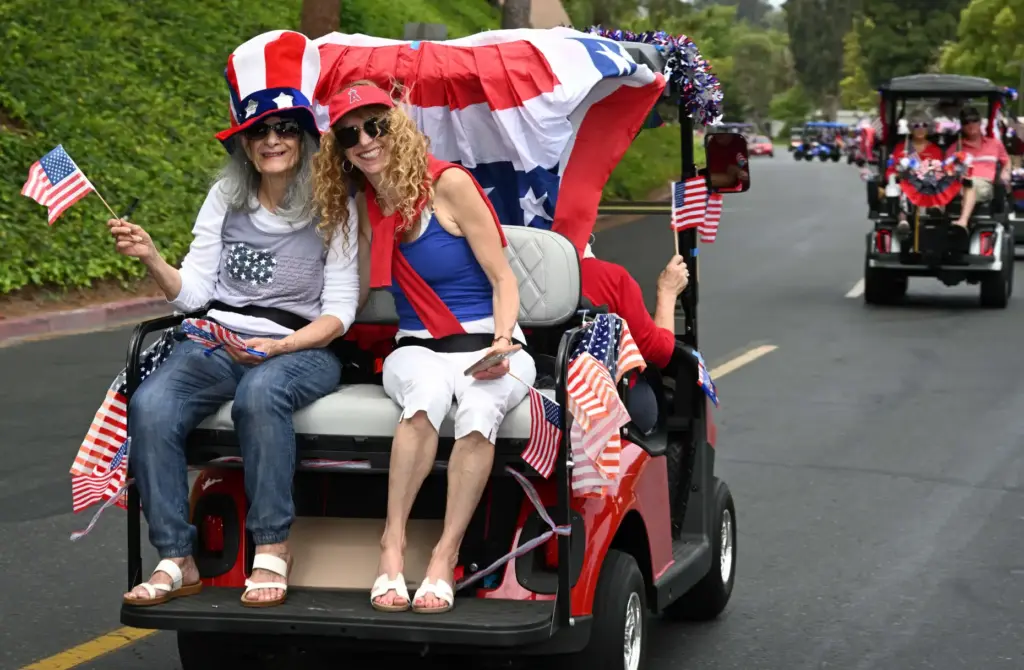 Decorated golf carts ride down Calle Aragon road during the...