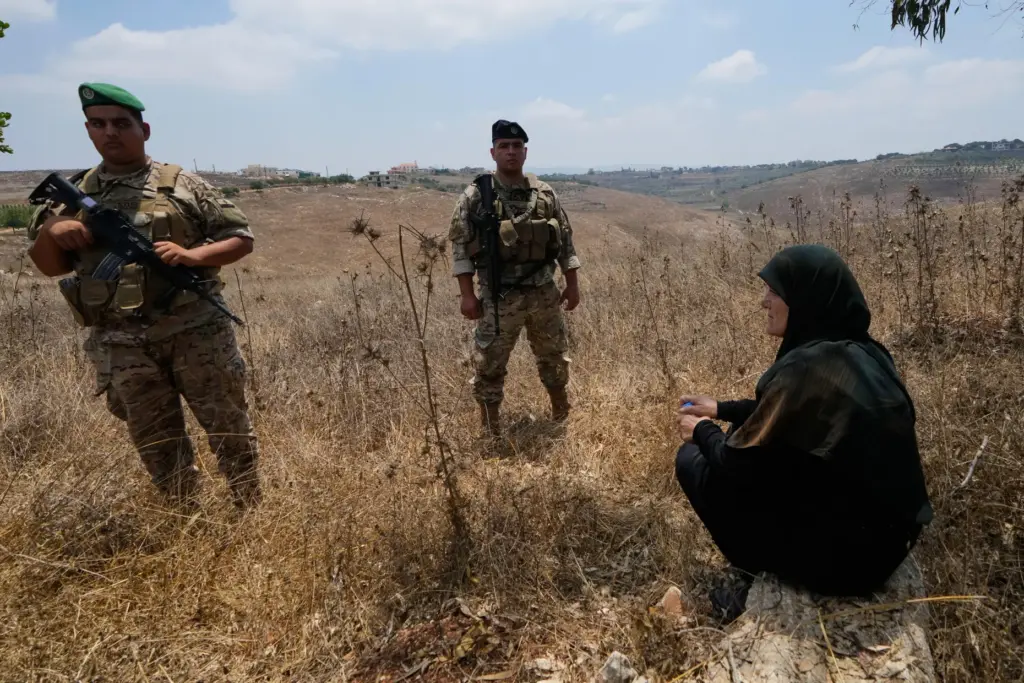 Lebanese army soldiers stand near a woman prevented from entering Zawtar Al Gharbieh.