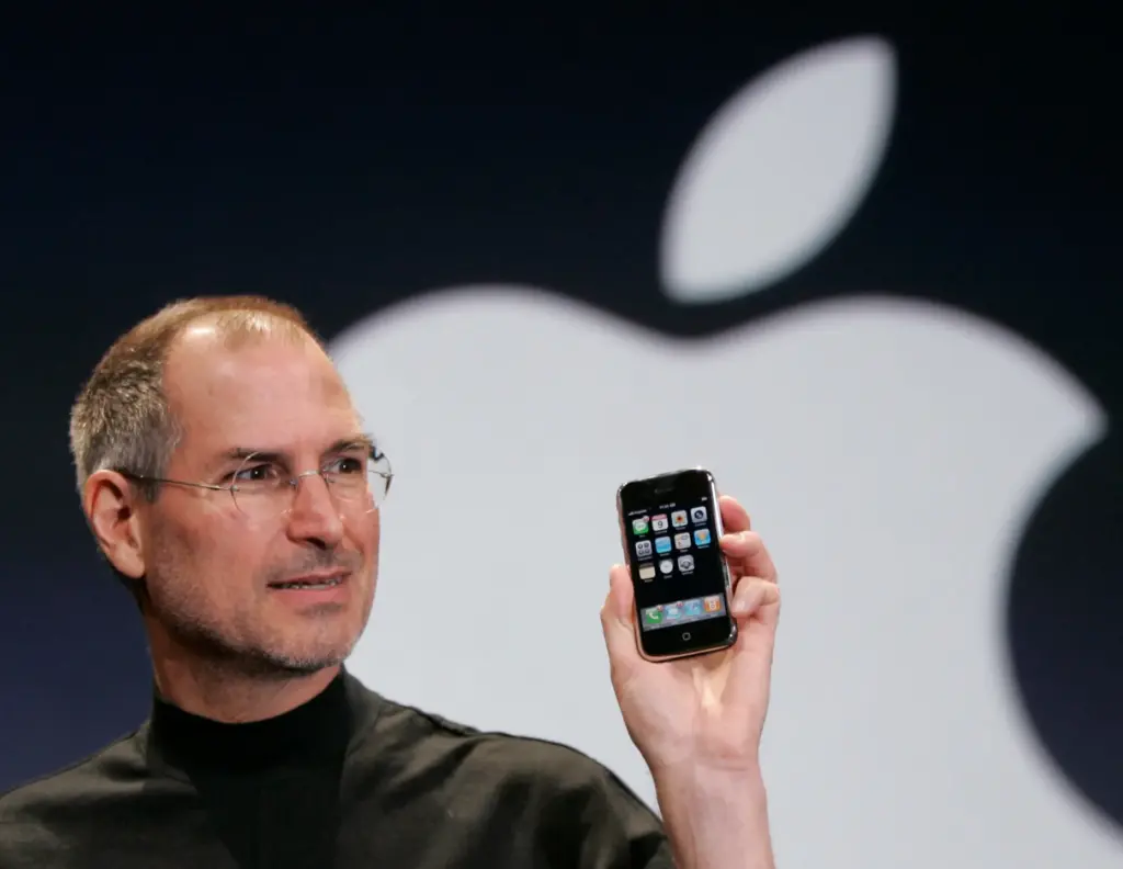 FILE – Apple CEO Steve Jobs holds up an Apple...