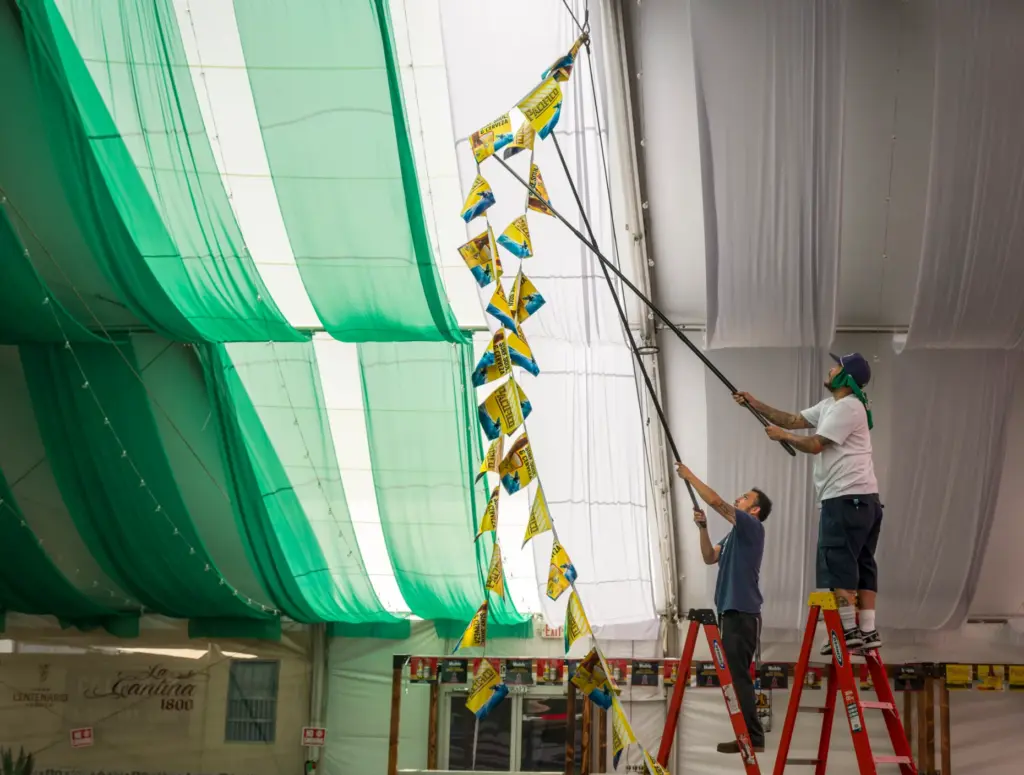 Jesus Flores, left, and Adrian Bermudez hang banners inside the...