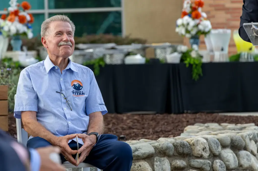 Master of Ceremonies Paul Miller sits and smiles while listening...