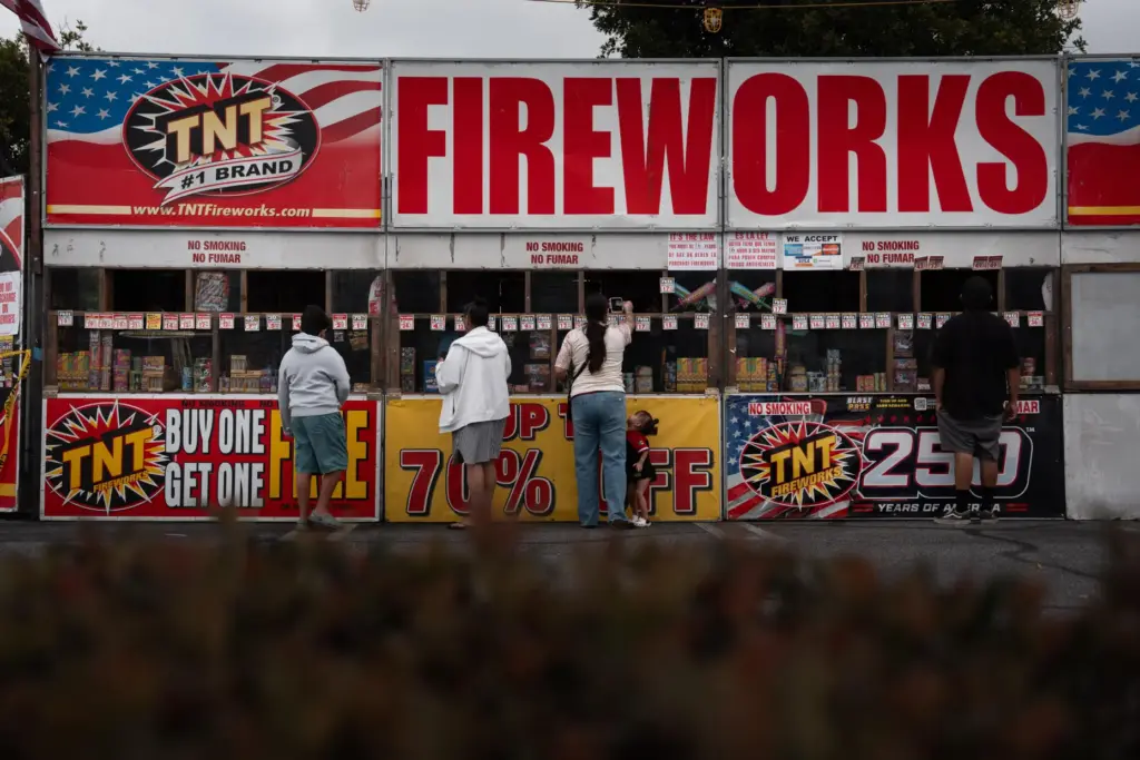 People purchase fireworks at a TNT Fireworks stand in Alhambra,...