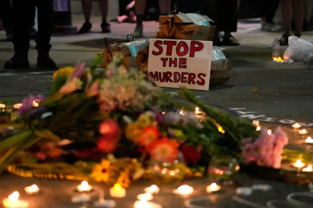 Attendees gather at a candlelight vigil where a Madison police...