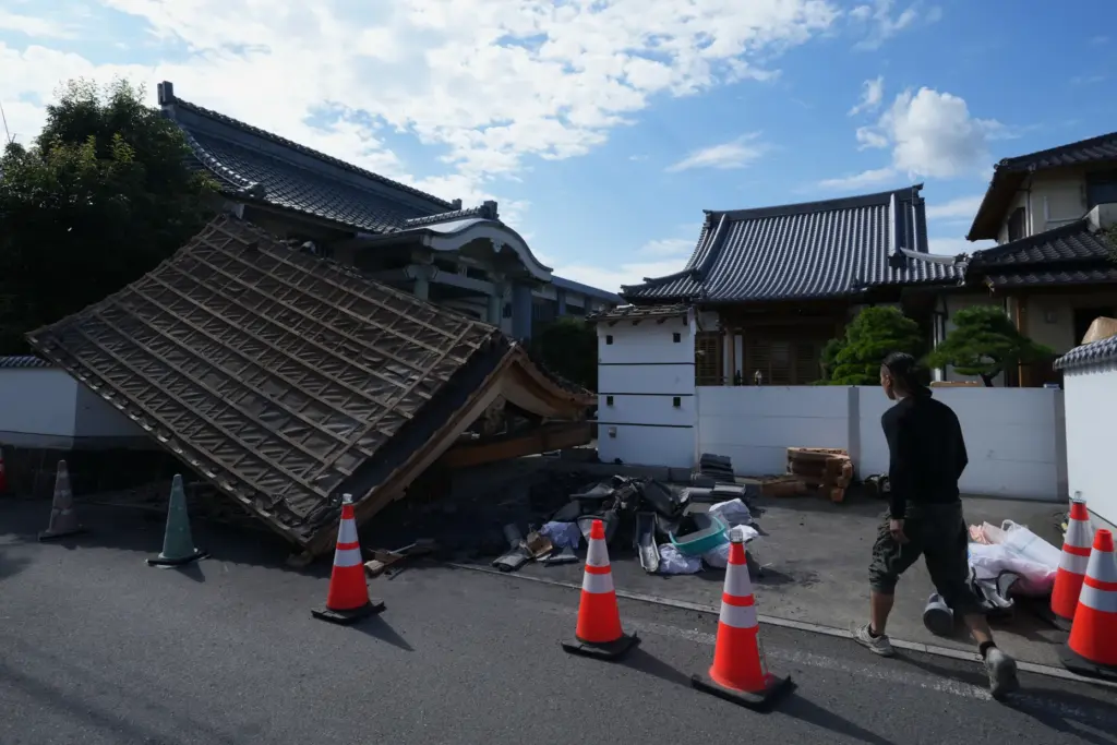 A man helps clean the damaged gate of Jofukuji Buddhist temple in Kumamoto, southwestern Japan.