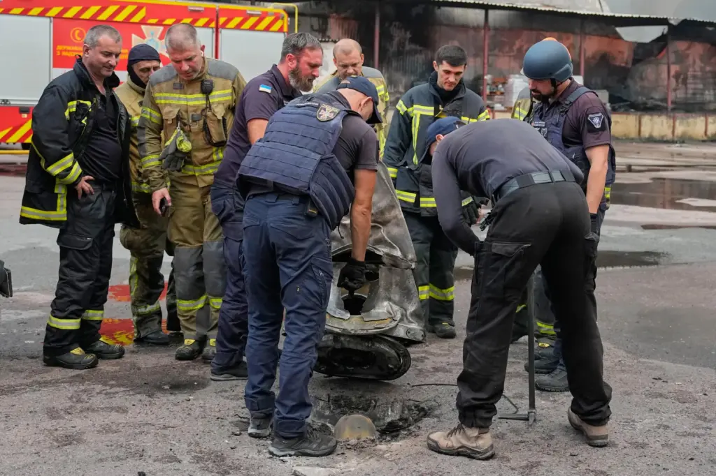Firefighters examine a fragment of a Russian missile in Kyiv, Ukraine.