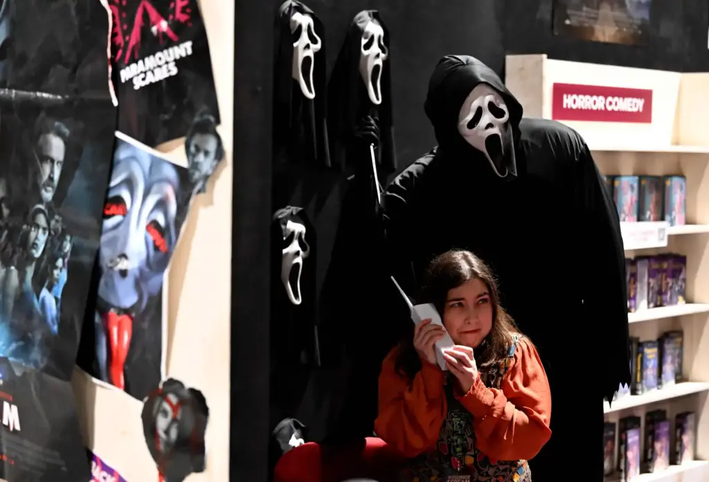 A fan poses with a charecter from the movie Scream...