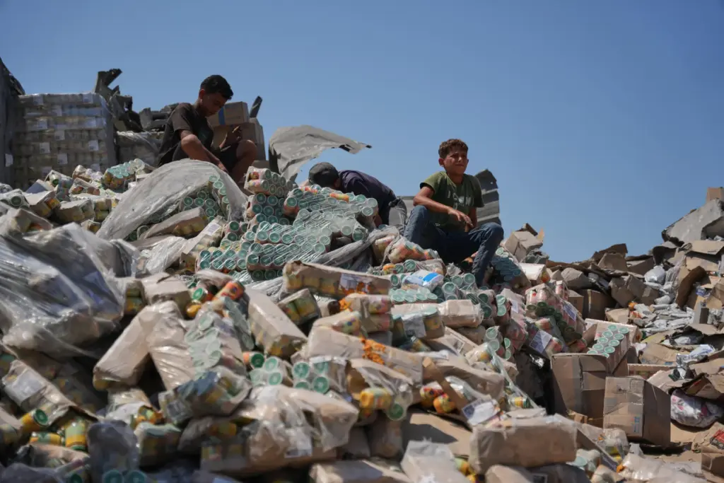 Palestinians look at a food-aid warehouse damaged in an Israeli airstrike.