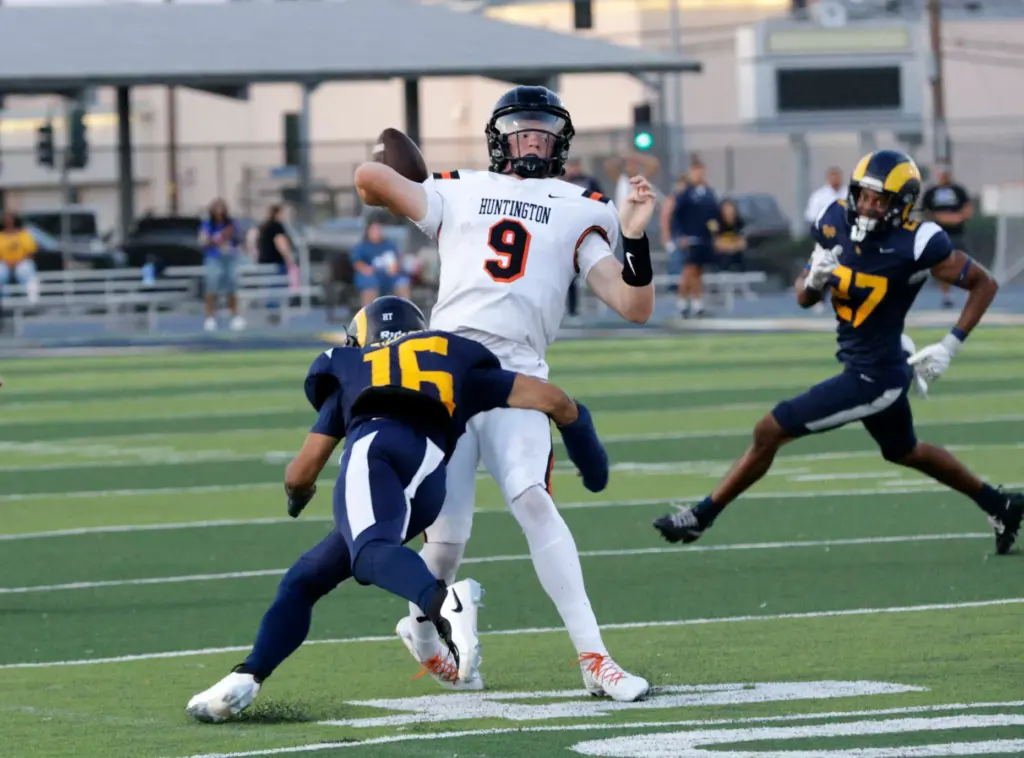 Huntington Beachs quarterback Brady Edmunds (9) tries to get a...