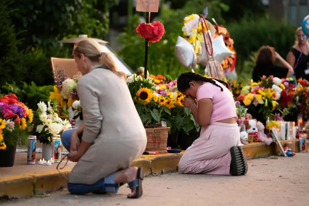 FILE – People pray at a memorial at Annunciation Catholic...