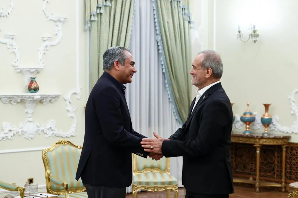 Iranian President Masoud Pezeshkian greets Pakistan's Interior Minister Mohsin Naqvi.