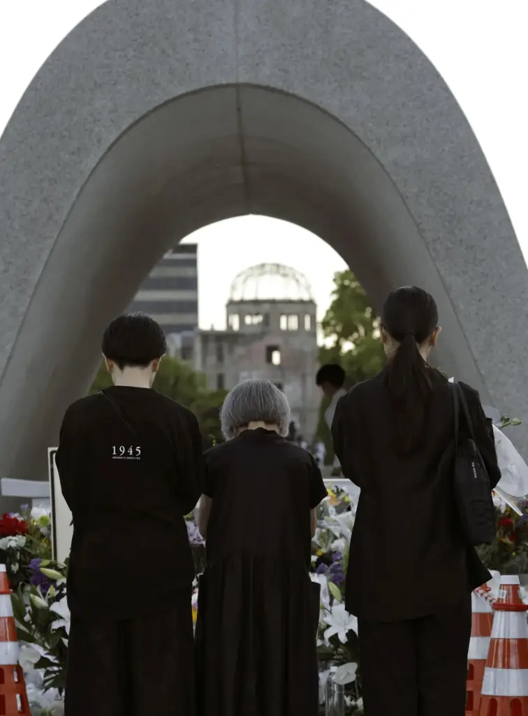 Visitors pray in front of the cenotaph dedicated to the victims of the atomic bombing.