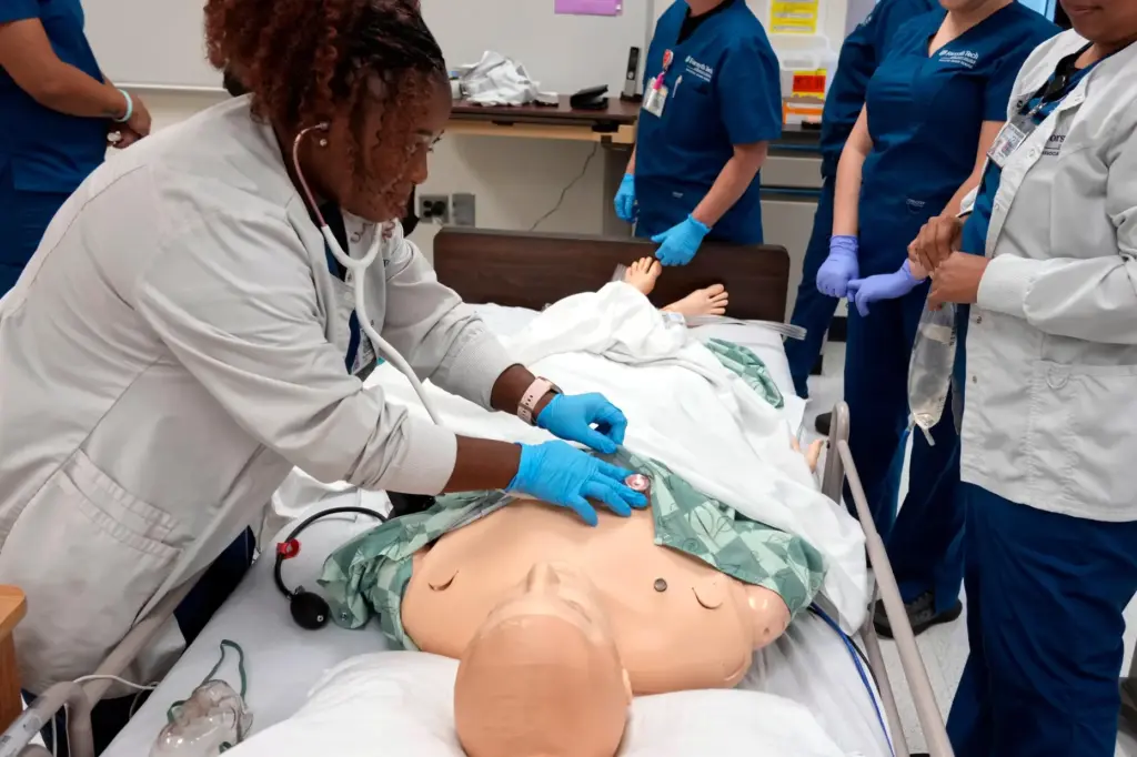 Nursing student Persis Coleman checks a manikin in the simulation lab.