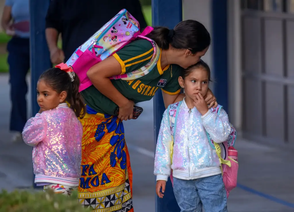 Meilani Menes comforts her daughters Kaiani, 5, right, and Katana,...