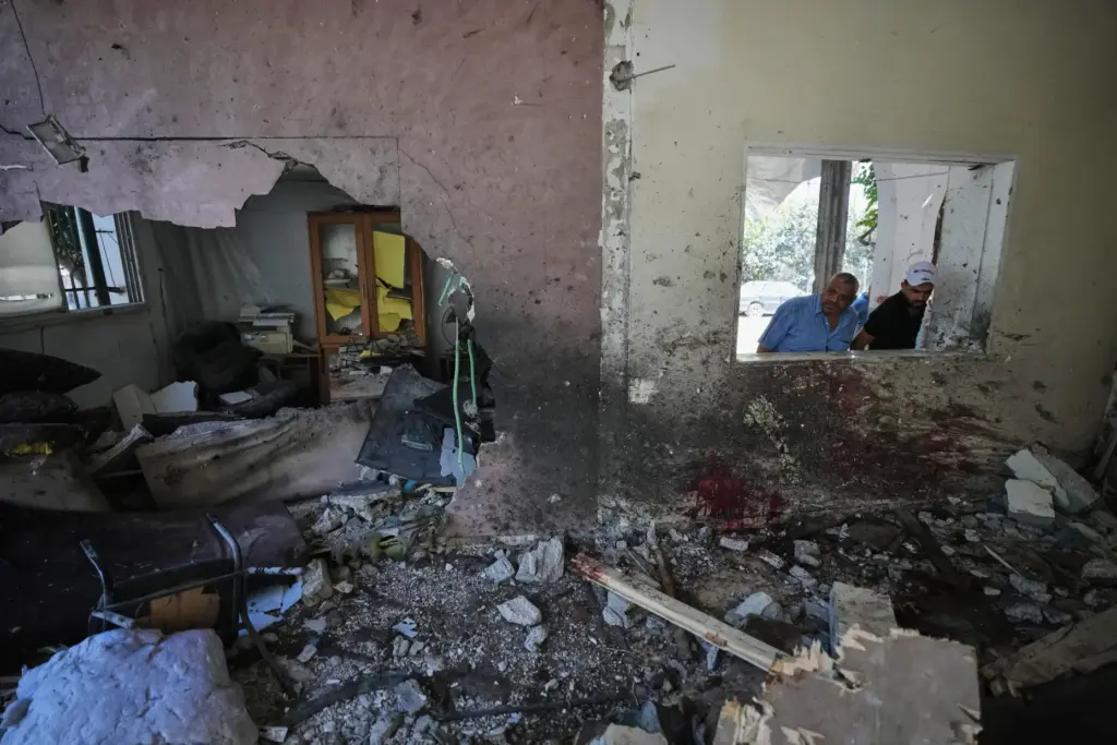 Palestinians inspect the damage at a police station that was hit by an Israeli airstrike.