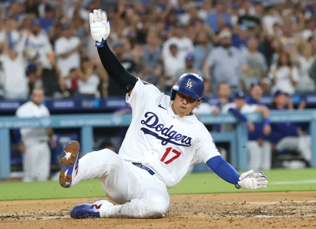 Dodgers star Shohei Ohtani slides home to score on a...