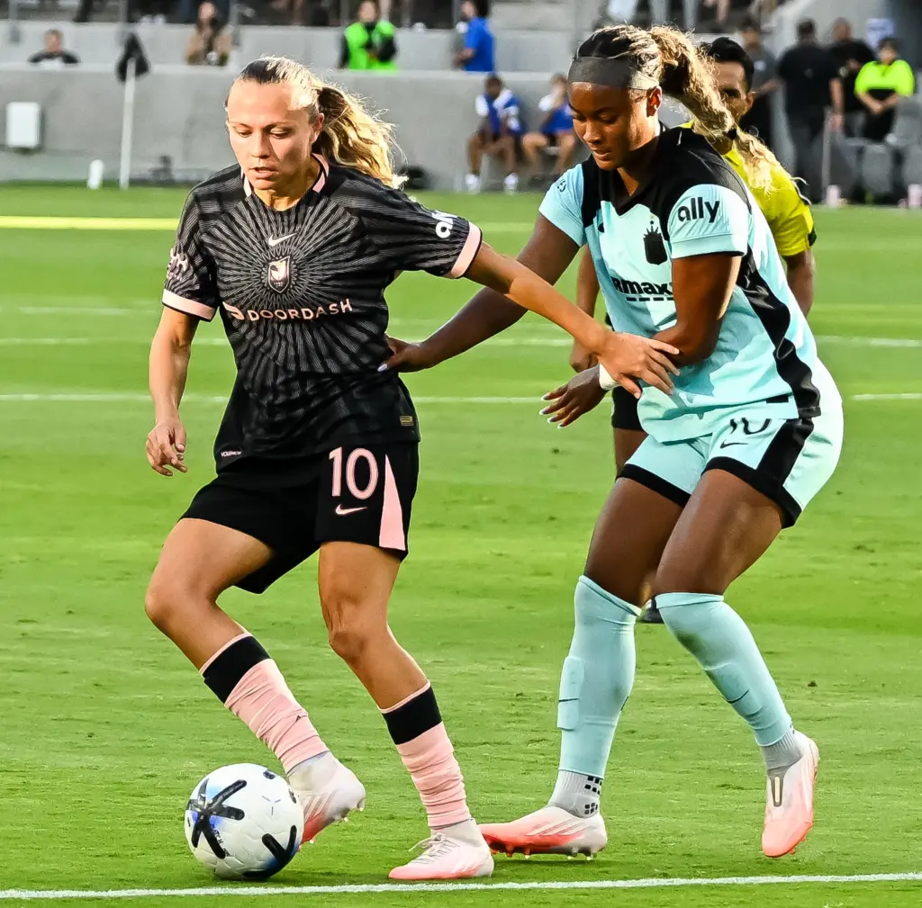 Angel City FC forward Claire Emslie (10) holds off a...