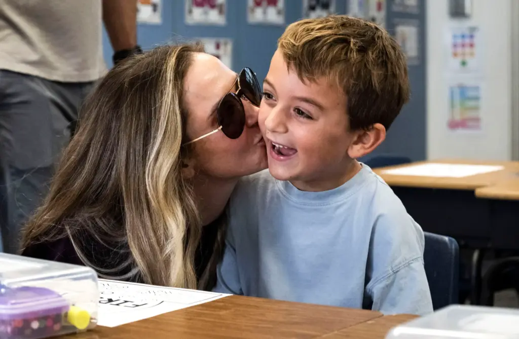 First-grade student Mateo Katavic gets a kiss from his mom...