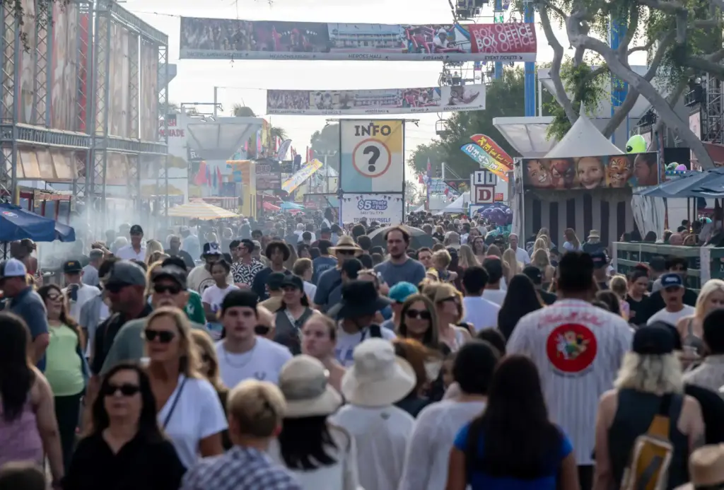 Thousands of fairgoers visit food and game booths at the...