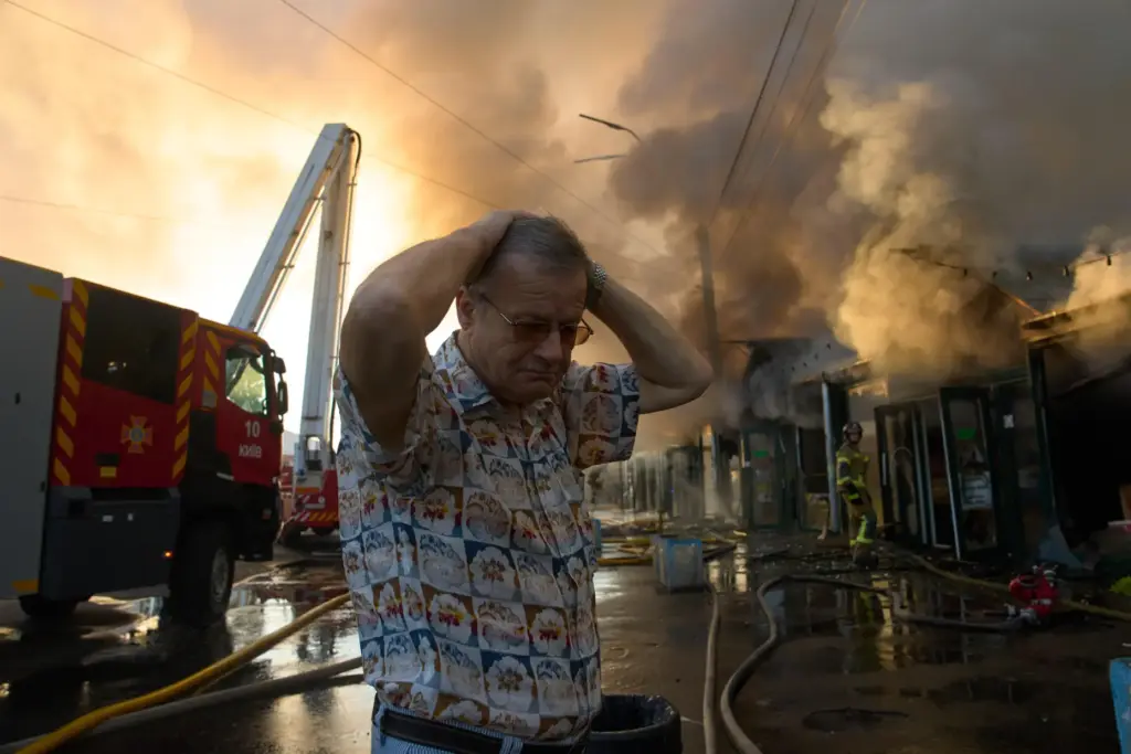 Bookseller Alexander Bahlai reacts as firefighters try to put out...