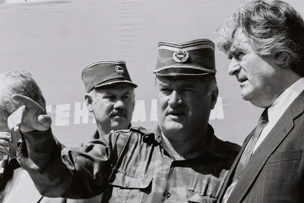 FILE – Bosnian Serb General Ratko Mladic, center, speaks with...