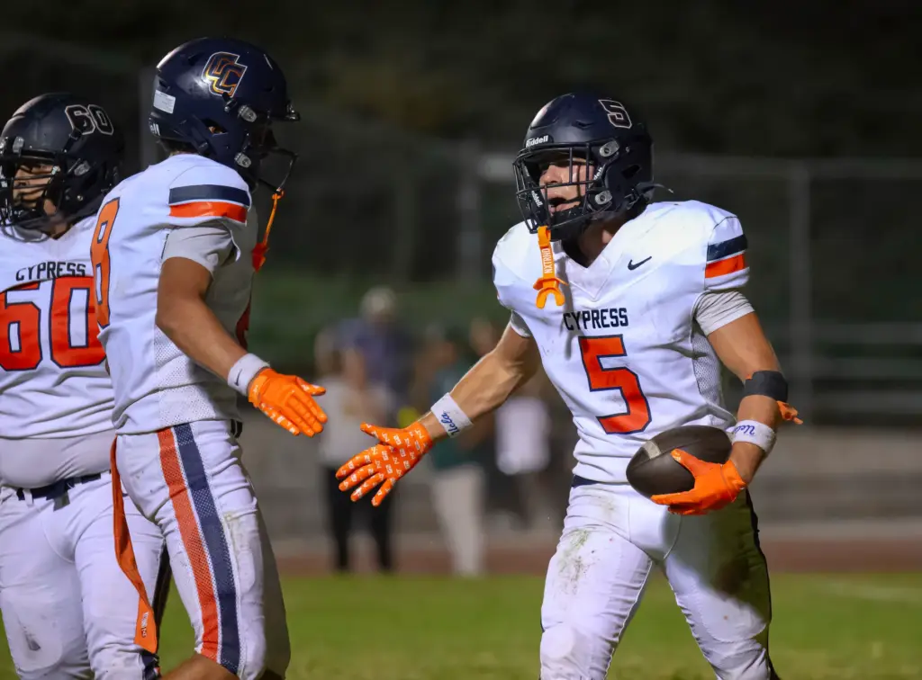 Cypress running back Louden Aljian, right, celebrates scoring a touchdown...