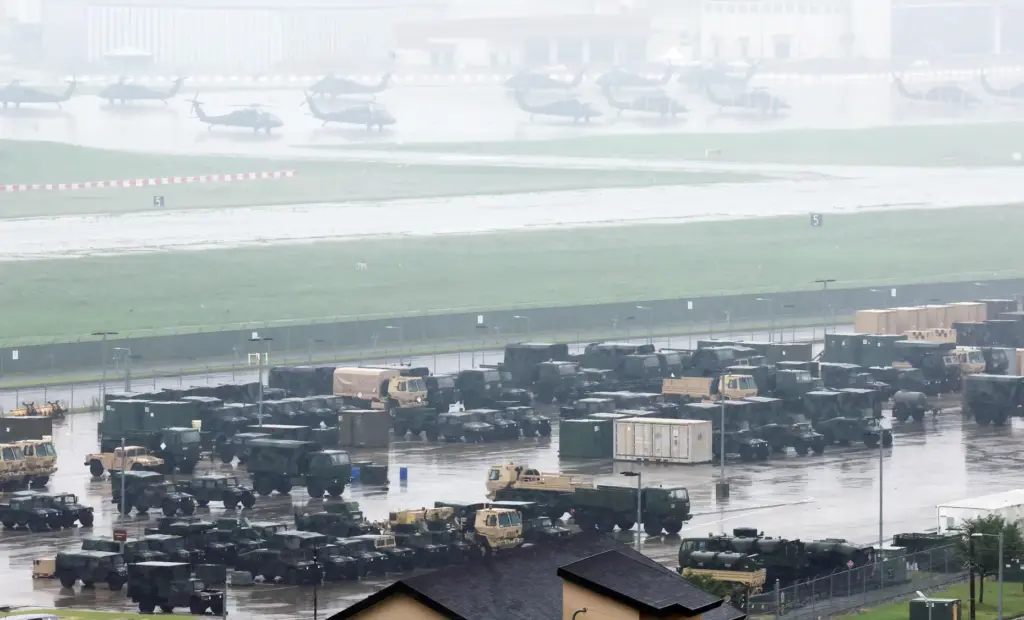U.S. military vehicles and Black Hawk helicopters are parked at...