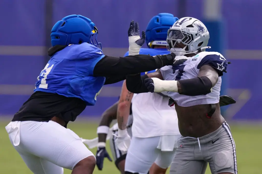 Dallas Cowboys outside linebacker Rashan Gary, right, tries to get...