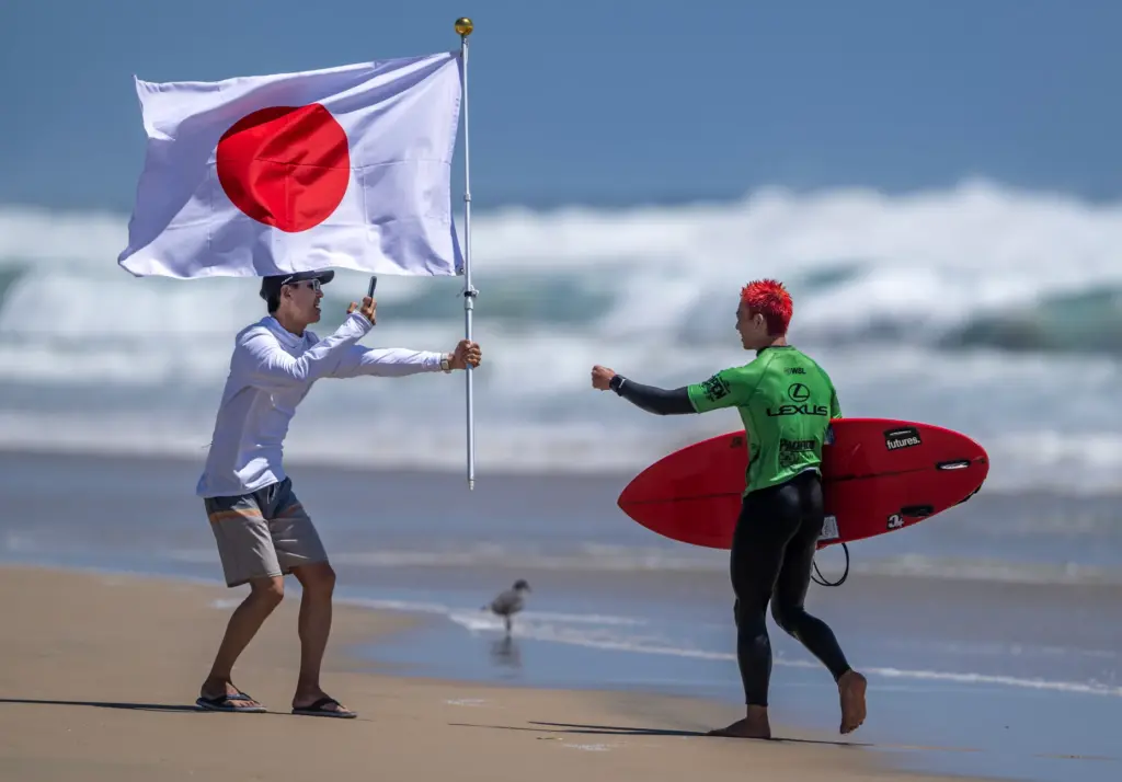 A fan waits to congratulate Japanese surfer Keijiro Nishi, with...
