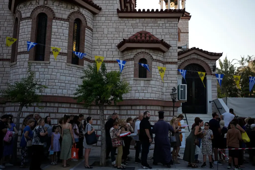 Pilgrims wait to have their Fanouropites, orange-flavored cakes, blessed.