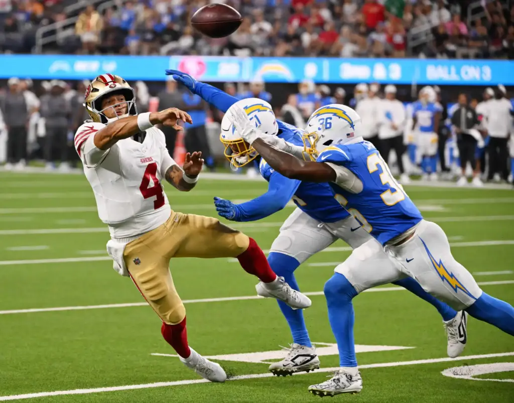 San Francisco 49ers quarterback Adrian Martinez, left, throws a pass...